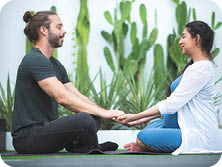 Young couple of beautiful pregnant woman and handsome husband practicing yoga and exercise in garden house.