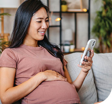 A woman is sitting on a couch and looking at her cell phone. AI generated content