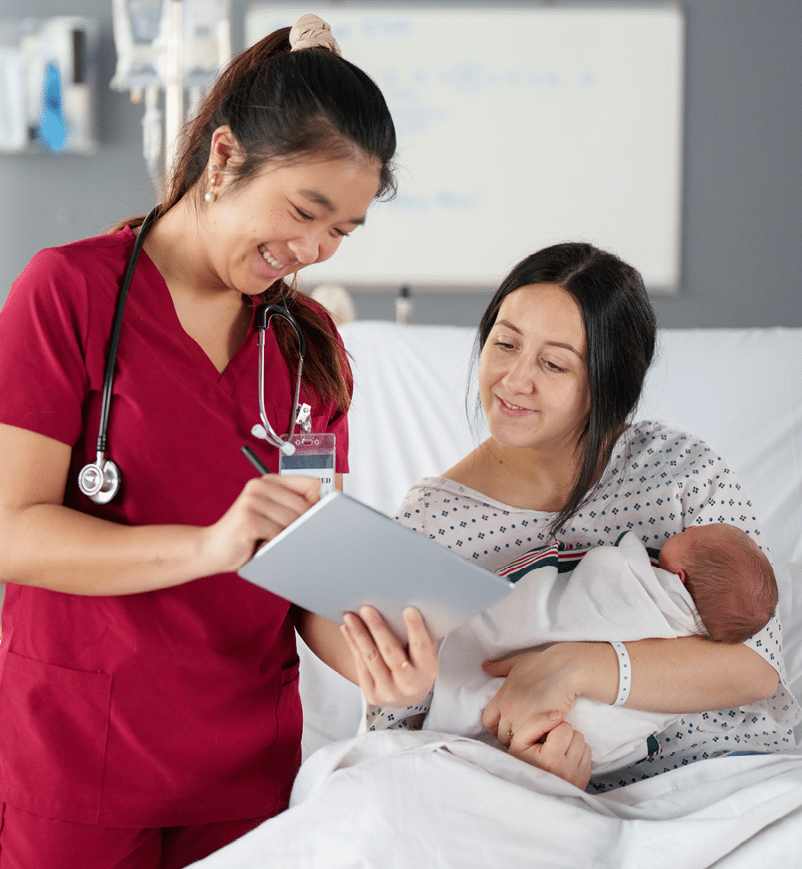 Two women in a hospital room, one holding a tablet and the other holding a baby. AI generated content